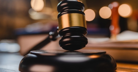 Selective focus photo of a gavel in a courtroom.